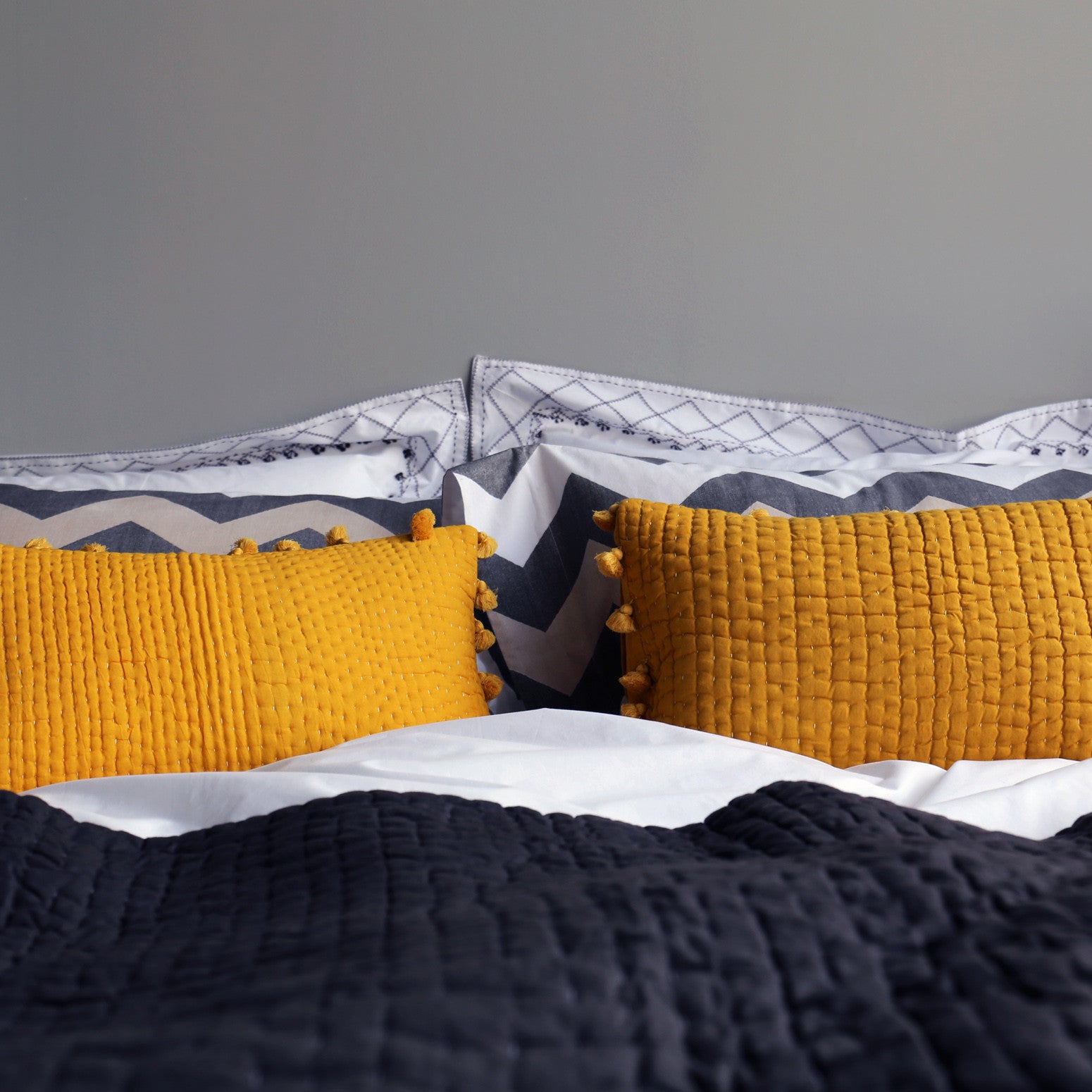 Yellow pompom quilted cushion