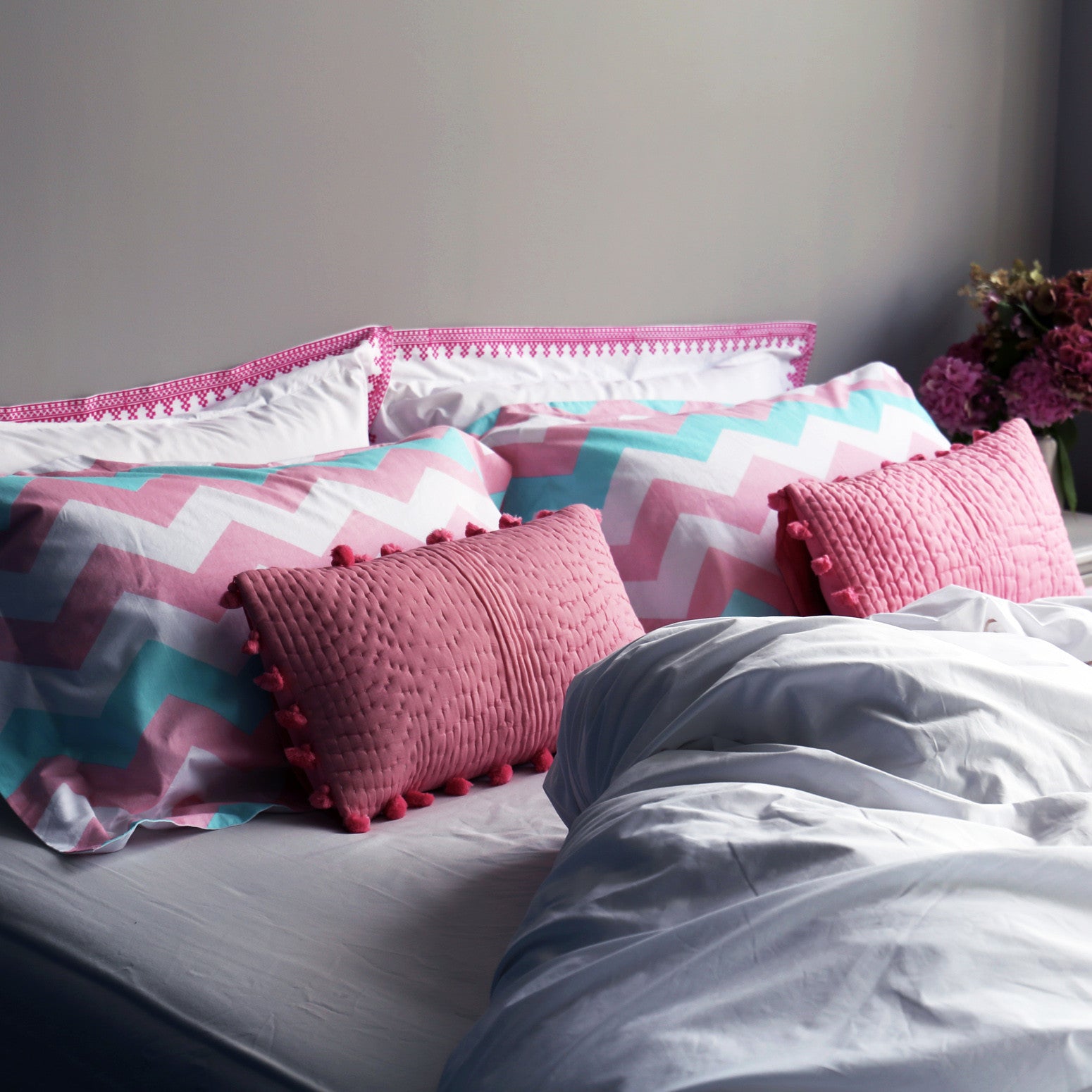 Pink pompom quilted cushion