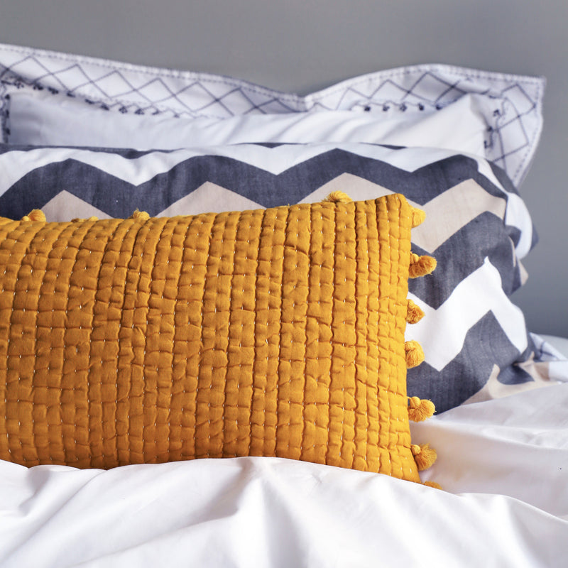 Yellow pompom quilted cushion