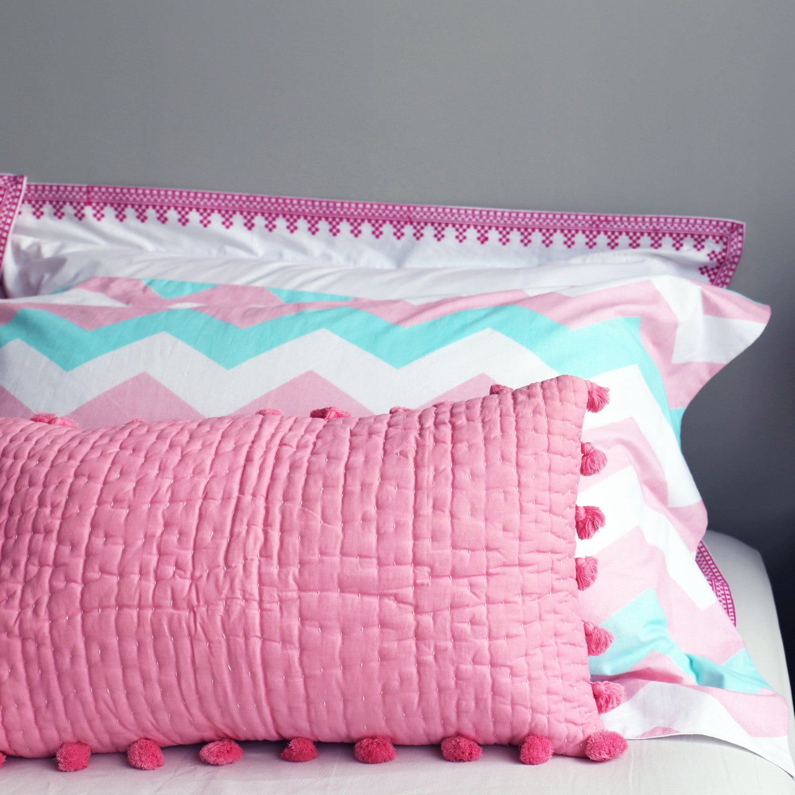 Pink pompom quilted cushion